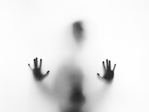 A figure behind frosted glass